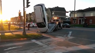 Tow truck drops car during risky lift