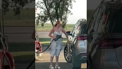 Woman has difficulty pumping Gas