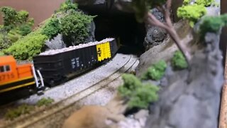 N scale trains racing out the tunnel.