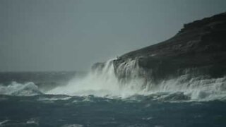 Man risks his life on cliff to film breaking waves