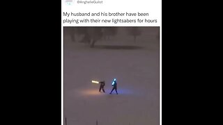 Two men are having fun playing with their lightsabers.