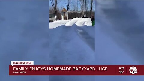 Family enjoys homemade backyard sled luge