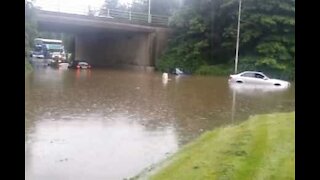 À vélo, il traverse une rue totalement inondée