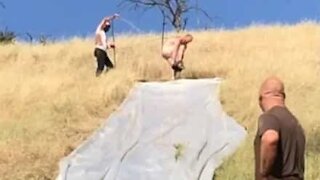 Naked guy meets a thorny end after slipping off giant slide