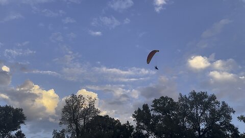 A pair of Paragliders flying about