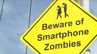 Crossing signs warn of people on phones