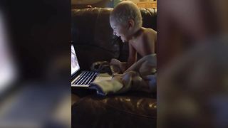 A Tot Boy Laughs At A Funny Video He Is Watching