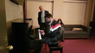 Travis Pangburn plays the piano for Richard Dawkins