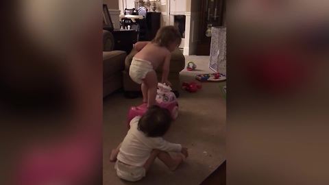 Tot Girls Push Each Other Off A Toy Car