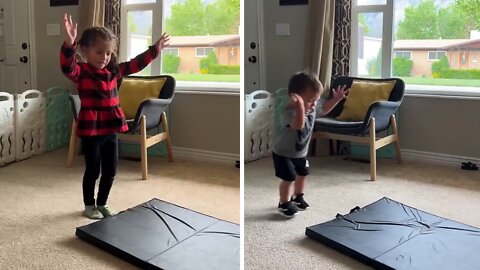 Toddler hilariously fails following big sister's gymnastics