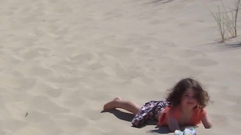 "Tot Girl Run Down Sand Dunes, But Trips Face Plants Into The Sand"