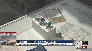 Learning to play marbles at National Museum of Toys and Miniatures