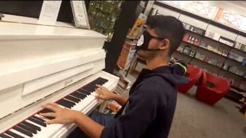 Young man plays the piano blindfolded