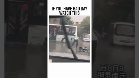 A good passenger in the bus drops off his umbrella for the traffic police guy, who is doing his duty