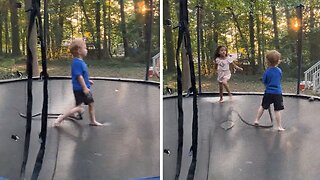 Kid casually plays with a snake on a trampoline