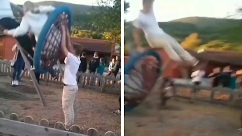 Man helping friend to swinging suddenly fell from the swing hilariously