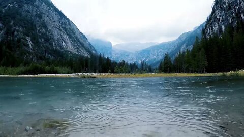 Soothing mountain rain on a lake, with occasional thunder rumbles