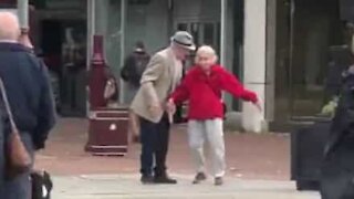 Un couple âgé et amoureux danse en pleine rue