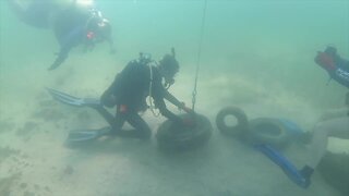 Divers pull old tires from bottom of Gulf