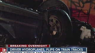 Driver taken to hospital after flipping car on tracks