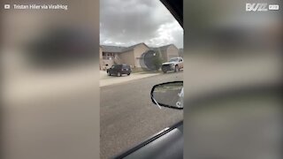 Massive trampoline rolls down the road and hits vehicle