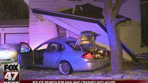 Police search for suspect who crashed into Lansing home