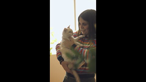 A woman petting and talking with her cat