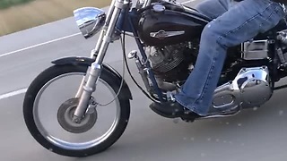 Girl Films A Man Riding A Motorcycle While Using A Phone