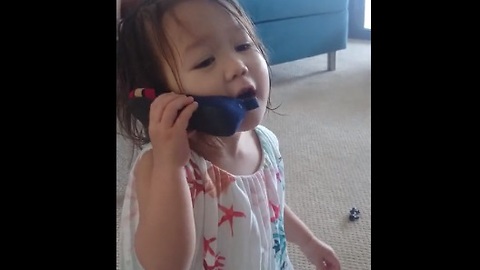 Toddler on "cell phone" is deep in conversation