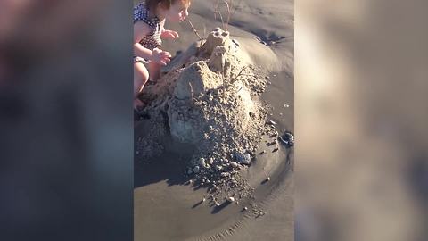 A Tot Girl Crashes A Sand Castle On A Beach
