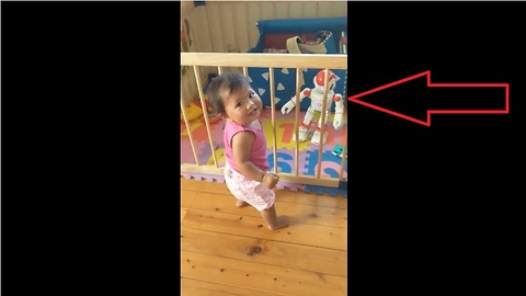 Baby dances along to toy robot