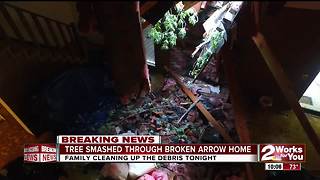 A tree goes through a Broken Arrow woman's home as a tornado rips through Green Country