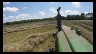 John Deere 40 tractor raking hay