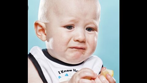 Cute babies eating sour lemon