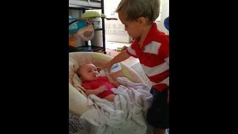 Big brother preciously watches over his baby sister