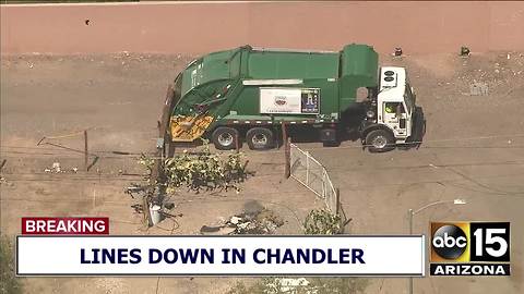 2 trapped after garbage truck hits power pole