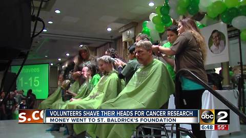 Volunteers shave their heads for childhood cancer research