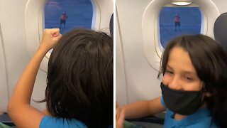 Airport employee plays "rock paper scissors" with kid on plane