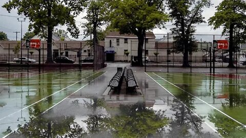 Rainfall over an empty basketball court in Hollis, Queens, New York
