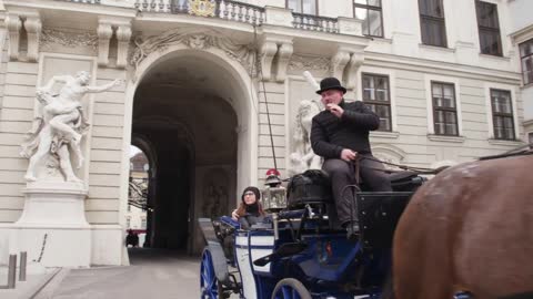 Tourist routes of the city of Vienna, tourists in horse carriages, a building in the Baroque style