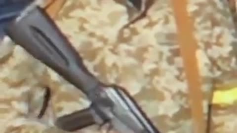 Humor - Soldado distraído com a arma no fundo da reportagem