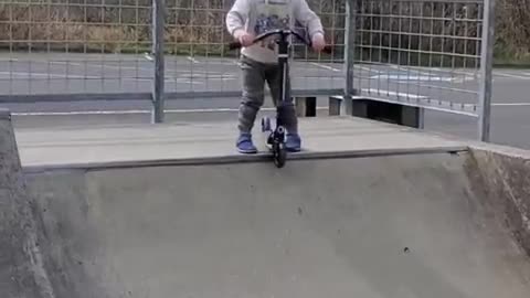 Toddler Imitates Dad's Pre-Run Warm-Up Ritual Before Sliding Down Ramp on Scooter
