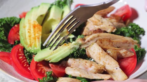 Chicken salad with tomato, avocado and kale in gray bowl. Is a healthy Energetic Recipe