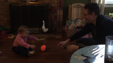 Baby learns how to effectively pass basketball