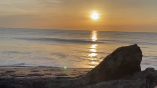 Sunrise with a log on the Beach