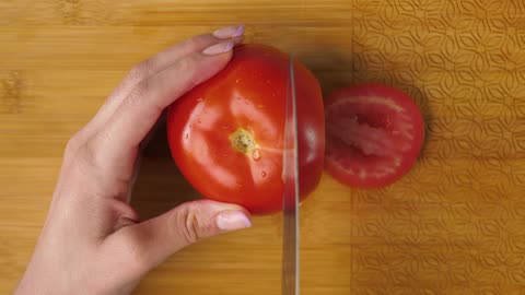 Woman slicing tomato on a board