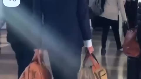 Biden walking thru airport with his own luggage