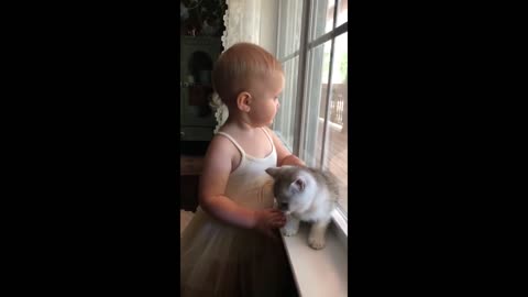 Baby girl adorably kisses her cute little kitten