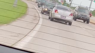 Car Drives in Reverse Down Busy Street