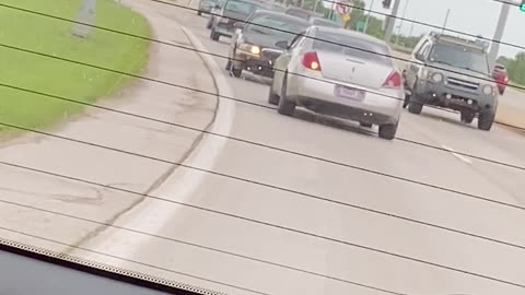 Car Drives in Reverse Down Busy Street